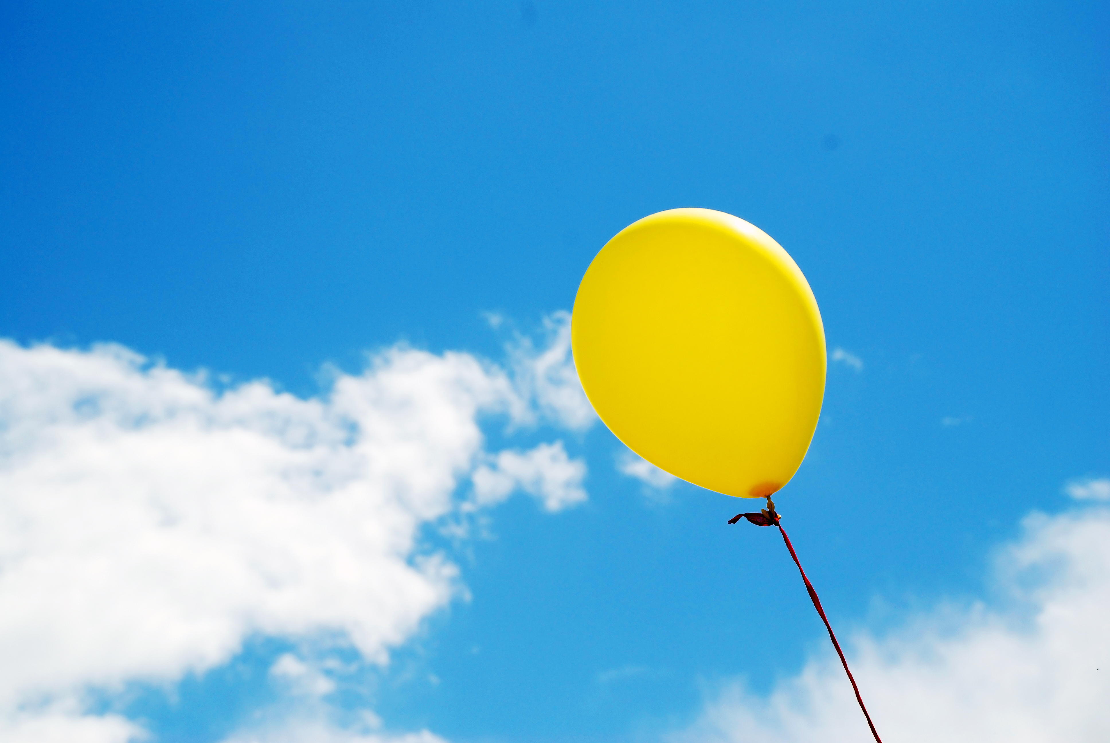 Yellow balloon in sky